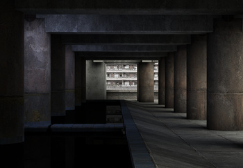 A brutalist scene of a hallway, lit by the sun through large columns on its right side, a tall building can be seen in the distance.